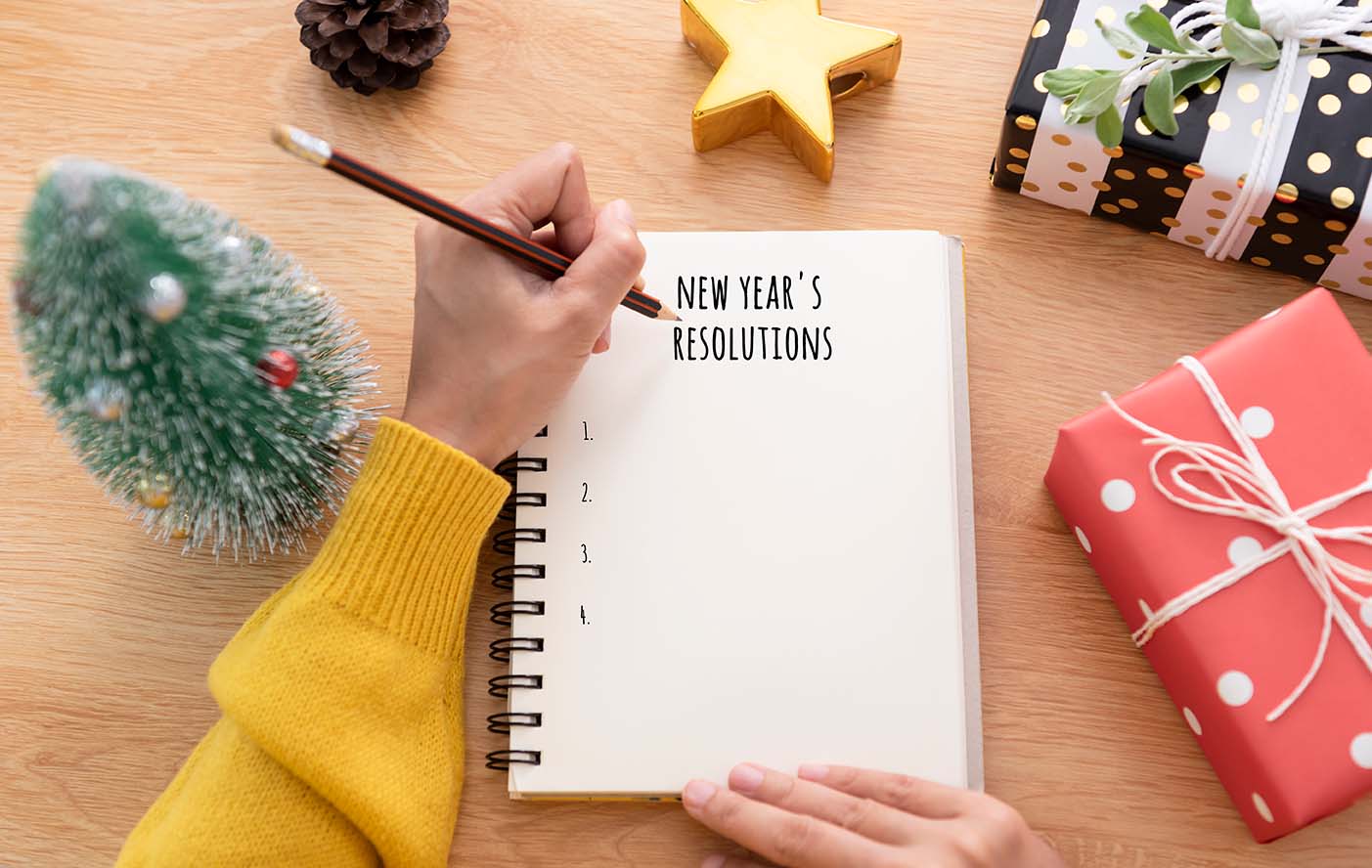 woman-hand-writing-new-years-resolution-note-paper-new-year-day